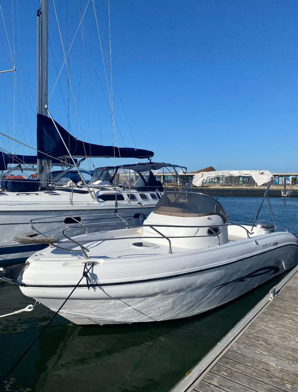 Ranieri Shadow 24 — Bateau à moteur blanc amarré dans un port, vu de trois quarts avant.