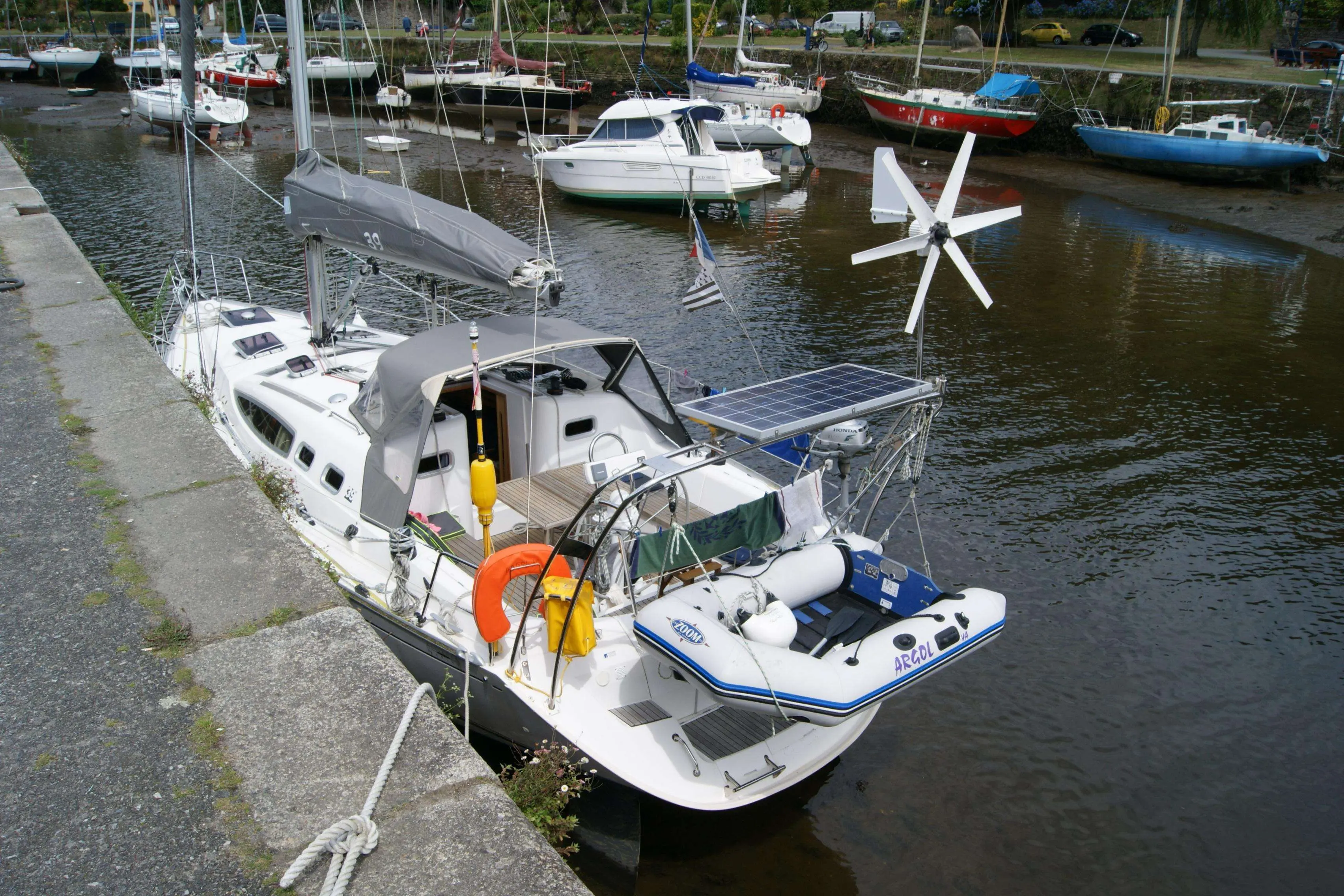 Kirie Feeling 39 — Voilier blanc amarré dans un port, équipé de panneaux solaires et d'une annexe.