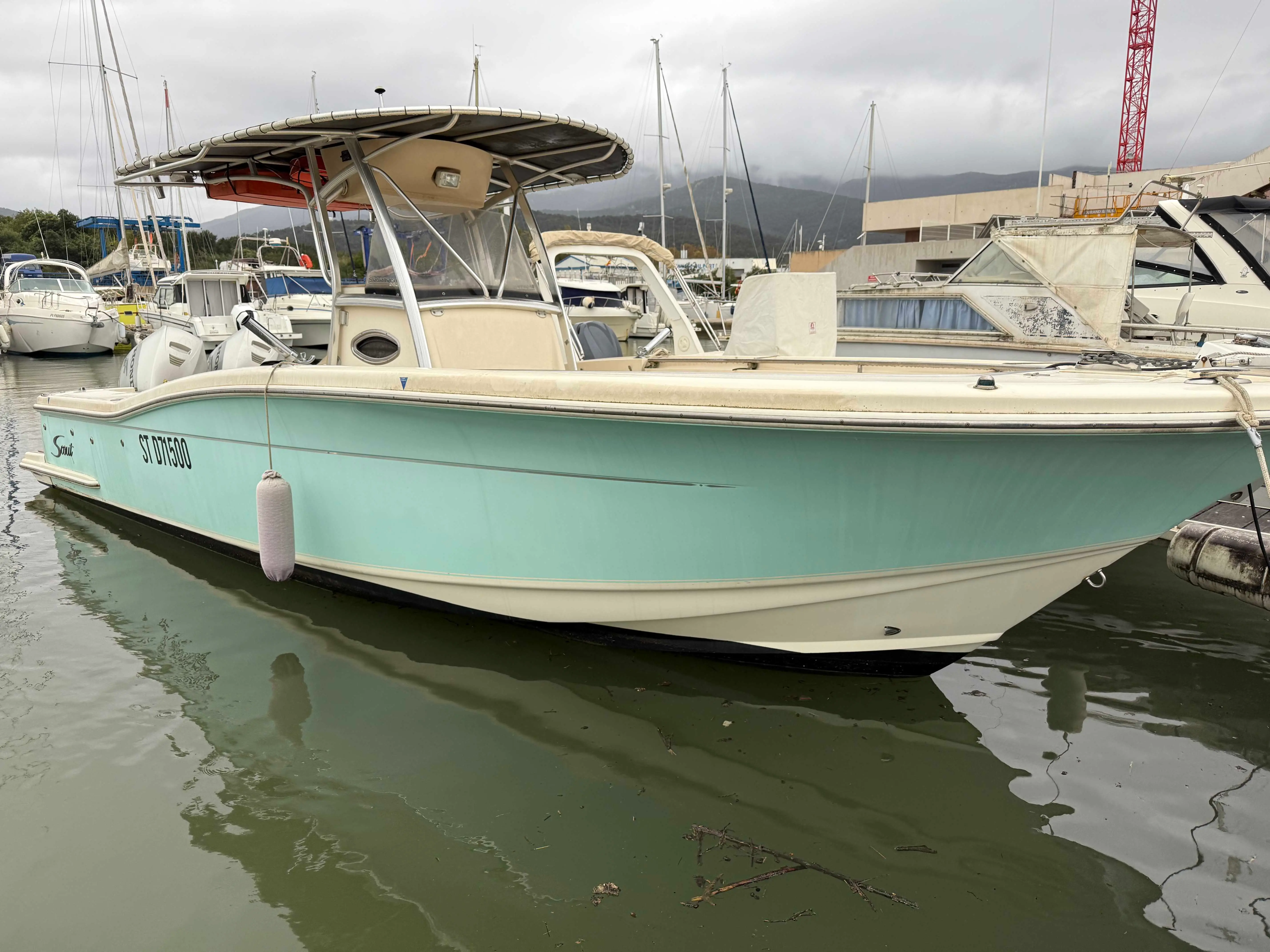 Scout Boat 262 Sport Fish — Bateau à console centrale amarré dans une marina, vu de trois quarts.