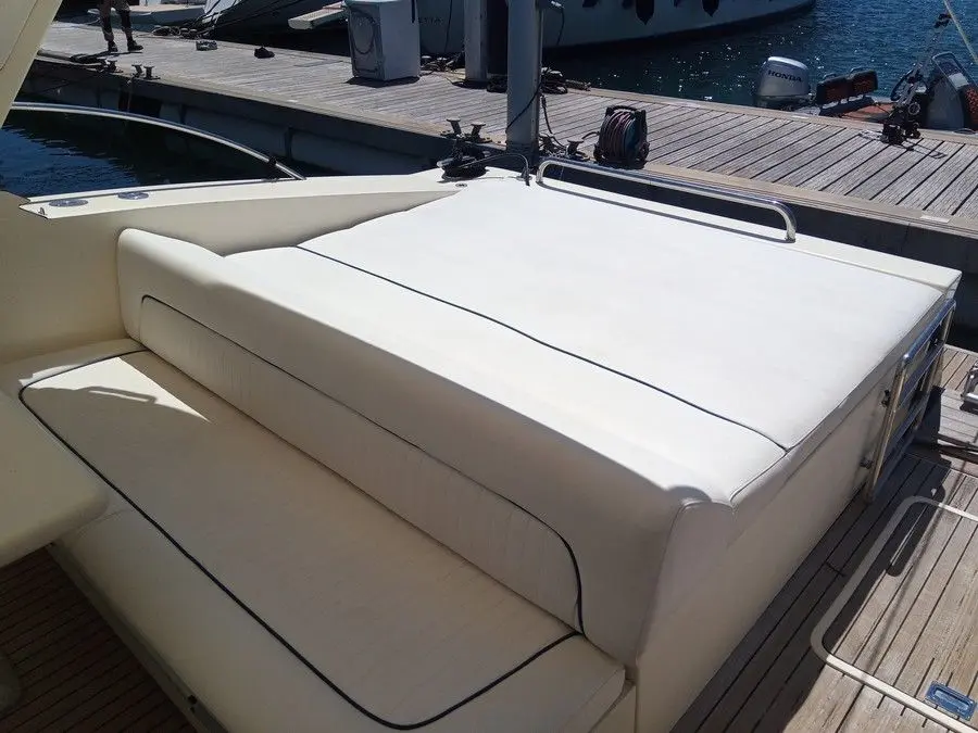 Ilver Mirable 41 — Vue rapprochée d’un bain de soleil et de sièges arrière sur un bateau au port.
