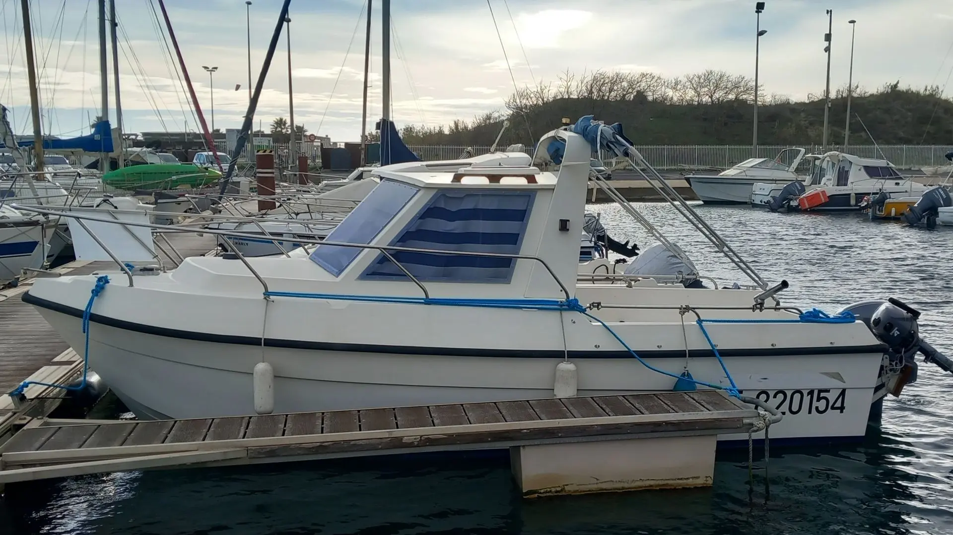 Clear Liner 600 — Bateau à moteur blanc amarré dans un port, vu de profil.