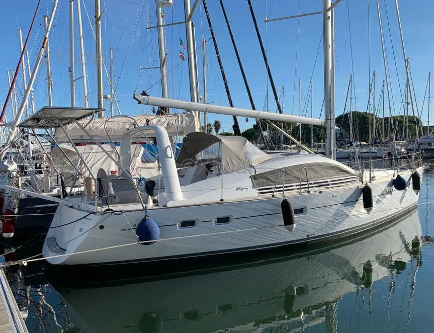 Wauquiez Pilot Saloon 47 — Voilier blanc amarré dans une marina, vu de trois quarts.