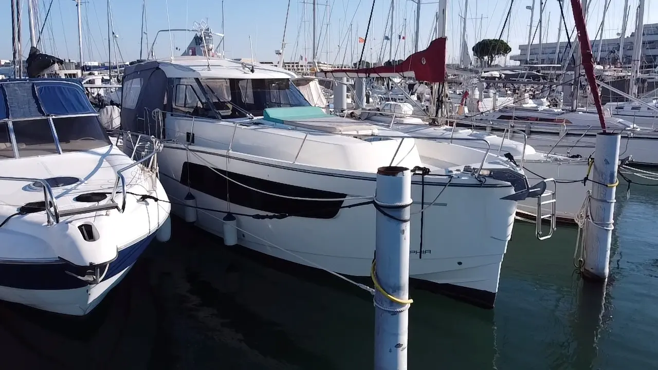 Delphia 1100 — Bateau à moteur blanc amarré dans une marina, vu de trois quarts avant.