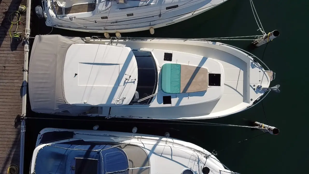 Delphia 1100 — Vue aérienne d’un bateau amarré, montrant son pont et son cockpit bâché.
