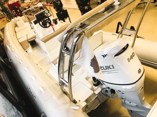Lomac 600 in — Vue plongeante d’un bateau pneumatique blanc avec console et moteur hors-bord.