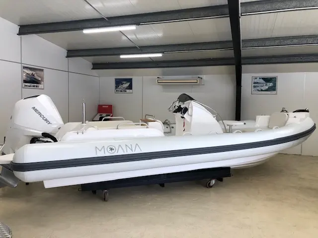Moana 700 — Bateau pneumatique blanc exposé à l’intérieur, posé sur sa remorque.