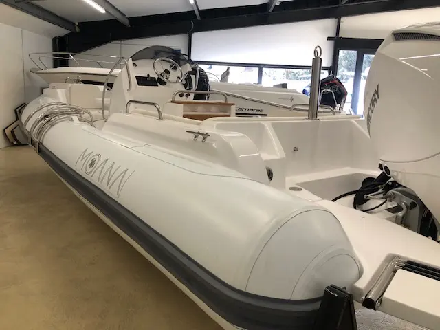Moana 700 — Bateau pneumatique blanc exposé à l’intérieur, vu en trois-quarts arrière.