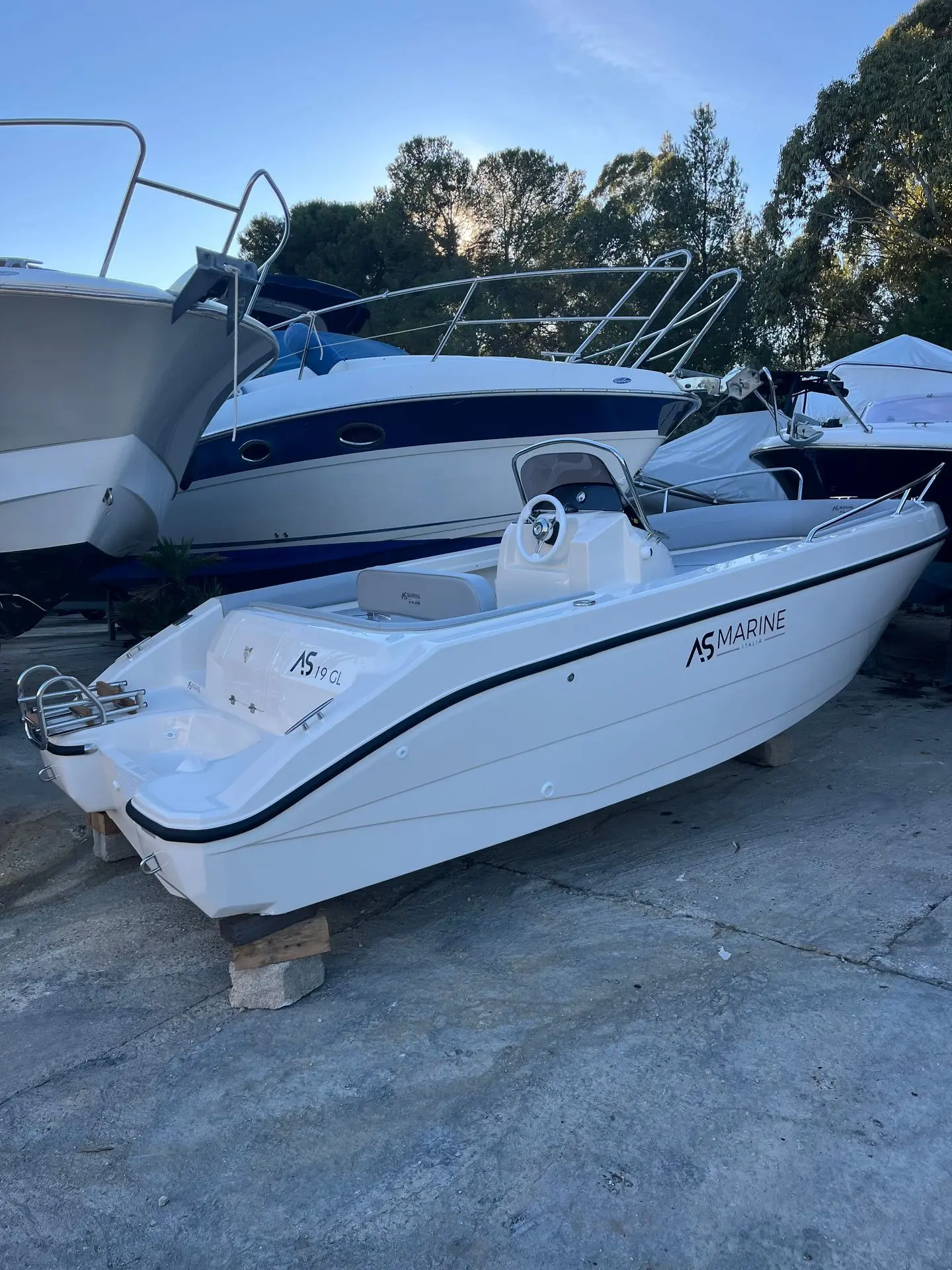 Eolo AS 19GL OPEN — Bateau à moteur blanc exposé à terre parmi d'autres embarcations.