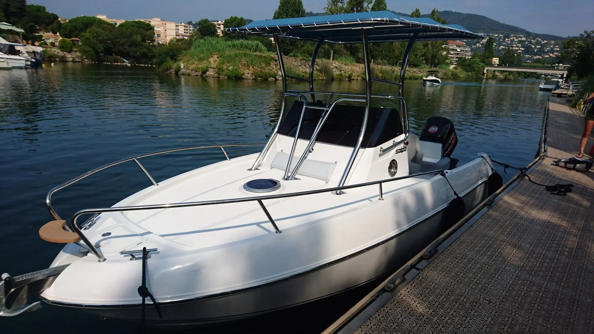 Salpa Granturismo 20 — Bateau à moteur blanc amarré à un ponton sur un plan d’eau.
