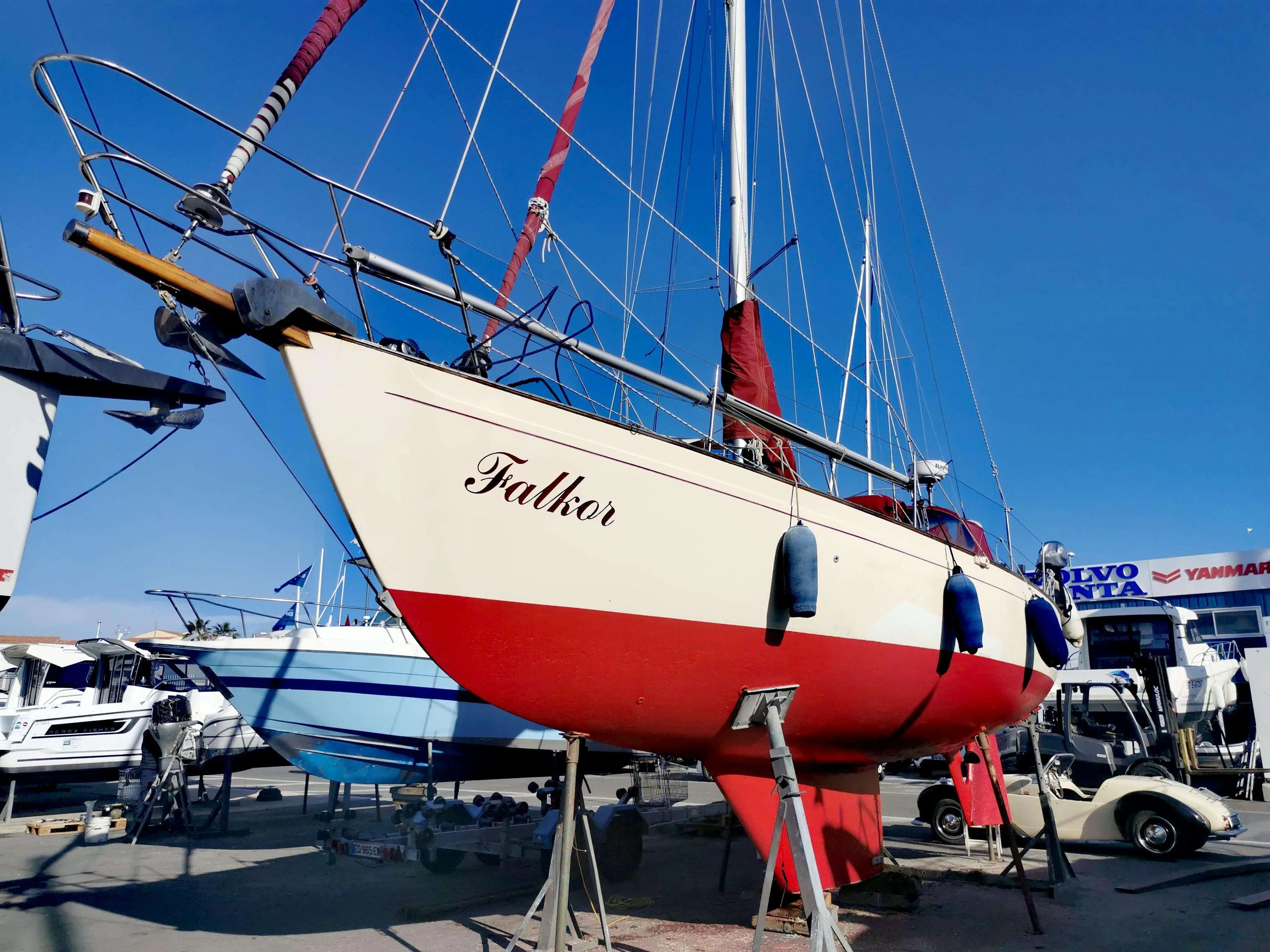 Victoria Yachts Victoria 34 — Voilier à coque blanche et rouge, posé à terre dans une concession nautique.
