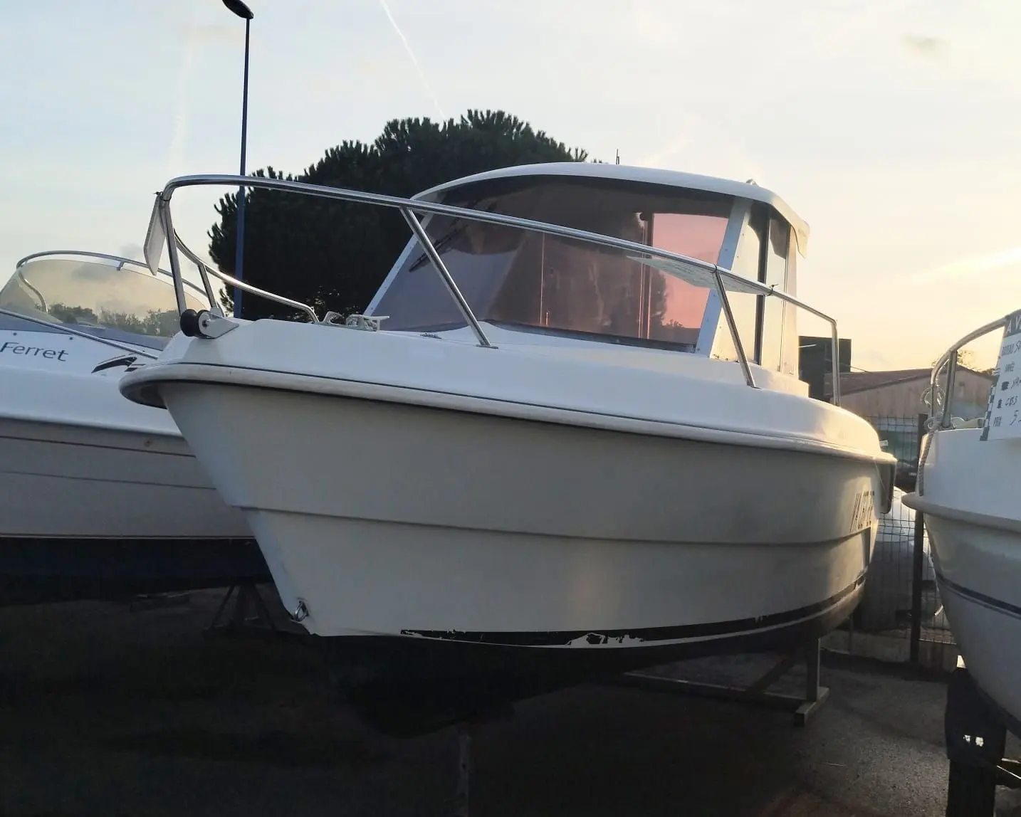 Guymarine GM 540 — Bateau à cabine photographié à terre entre deux autres embarcations.
