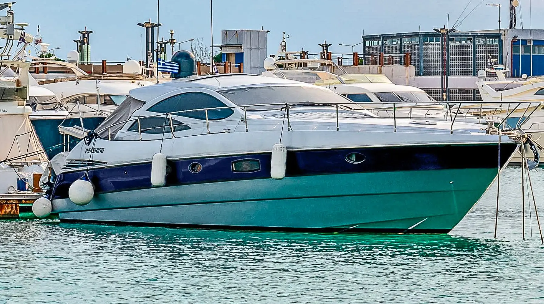 Pershing 50 — Vue latérale d’un bateau à moteur amarré dans une marina.