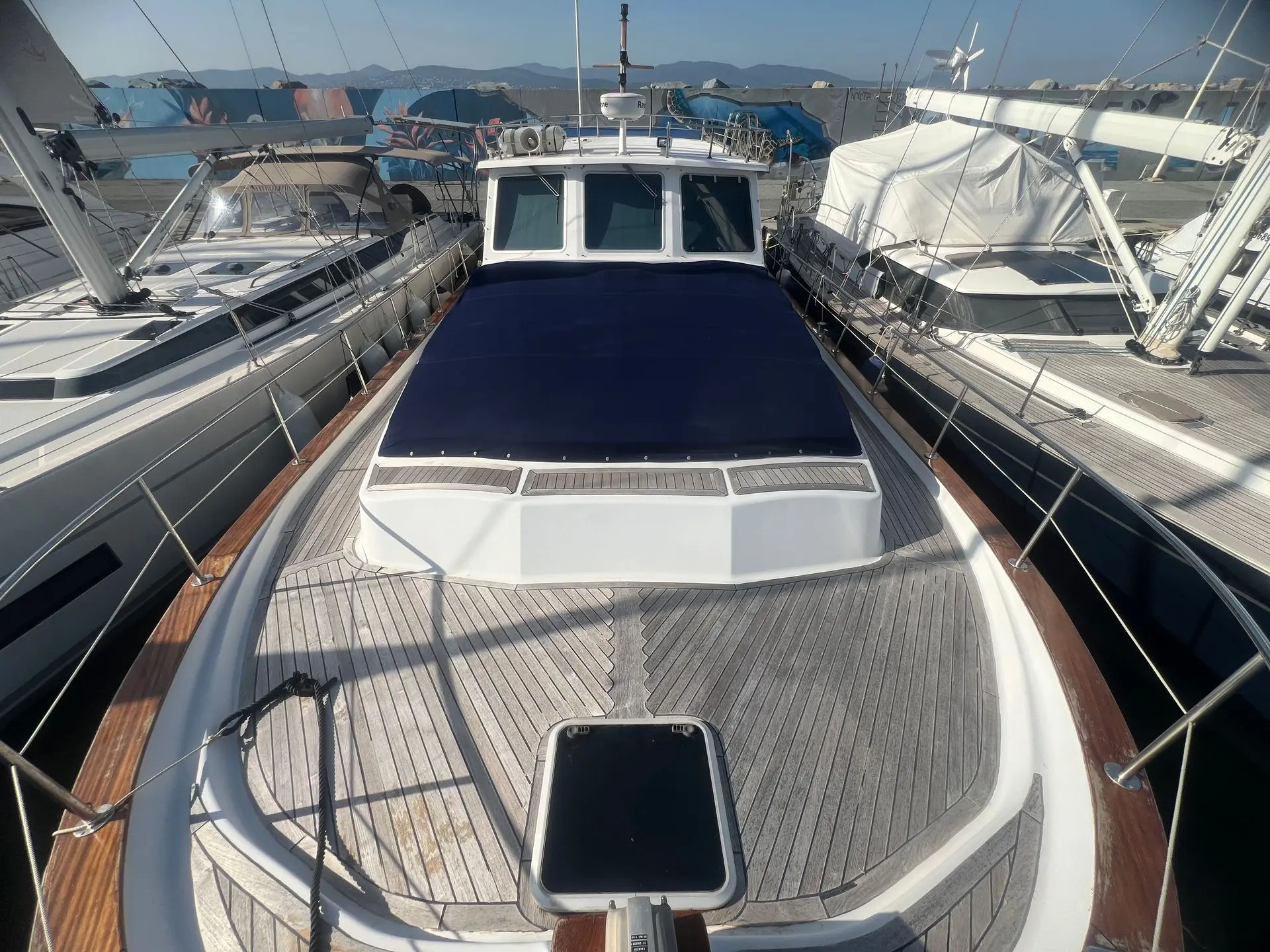 Menorquin 160 — Vue du pont avant et de la timonerie d’un bateau amarré dans une marina.