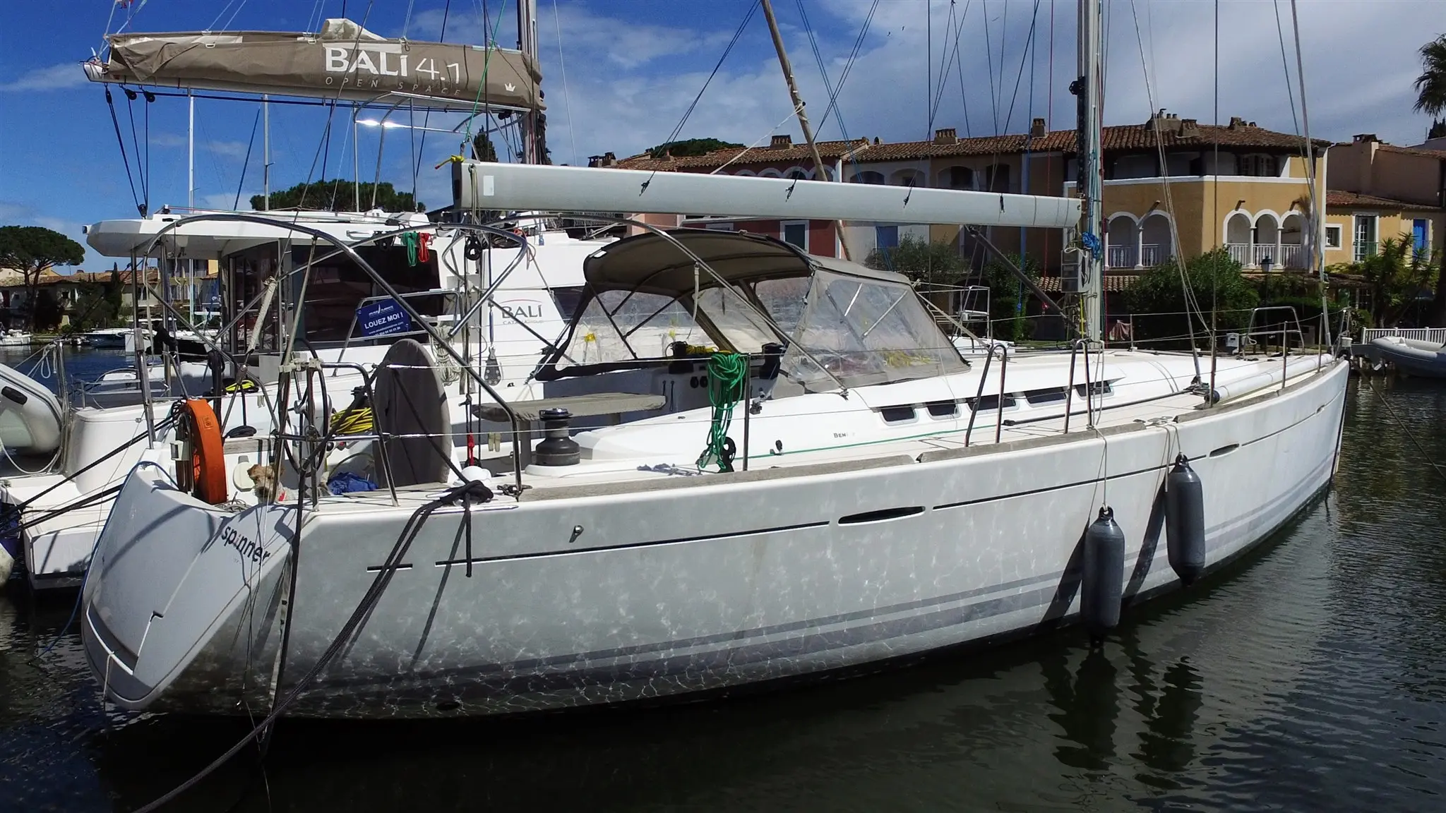 Beneteau First 50 — Voilier blanc amarré dans un port, photographié de trois quarts côté tribord.