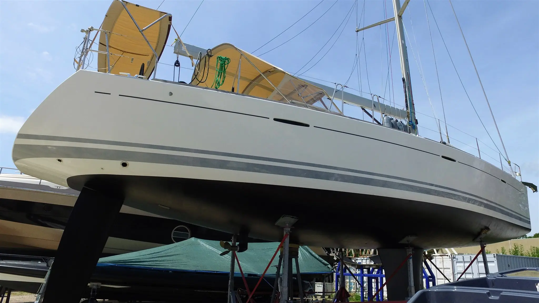 Beneteau First 50 — Voilier blanc à deux bandes grises, photographié à terre sur bers.