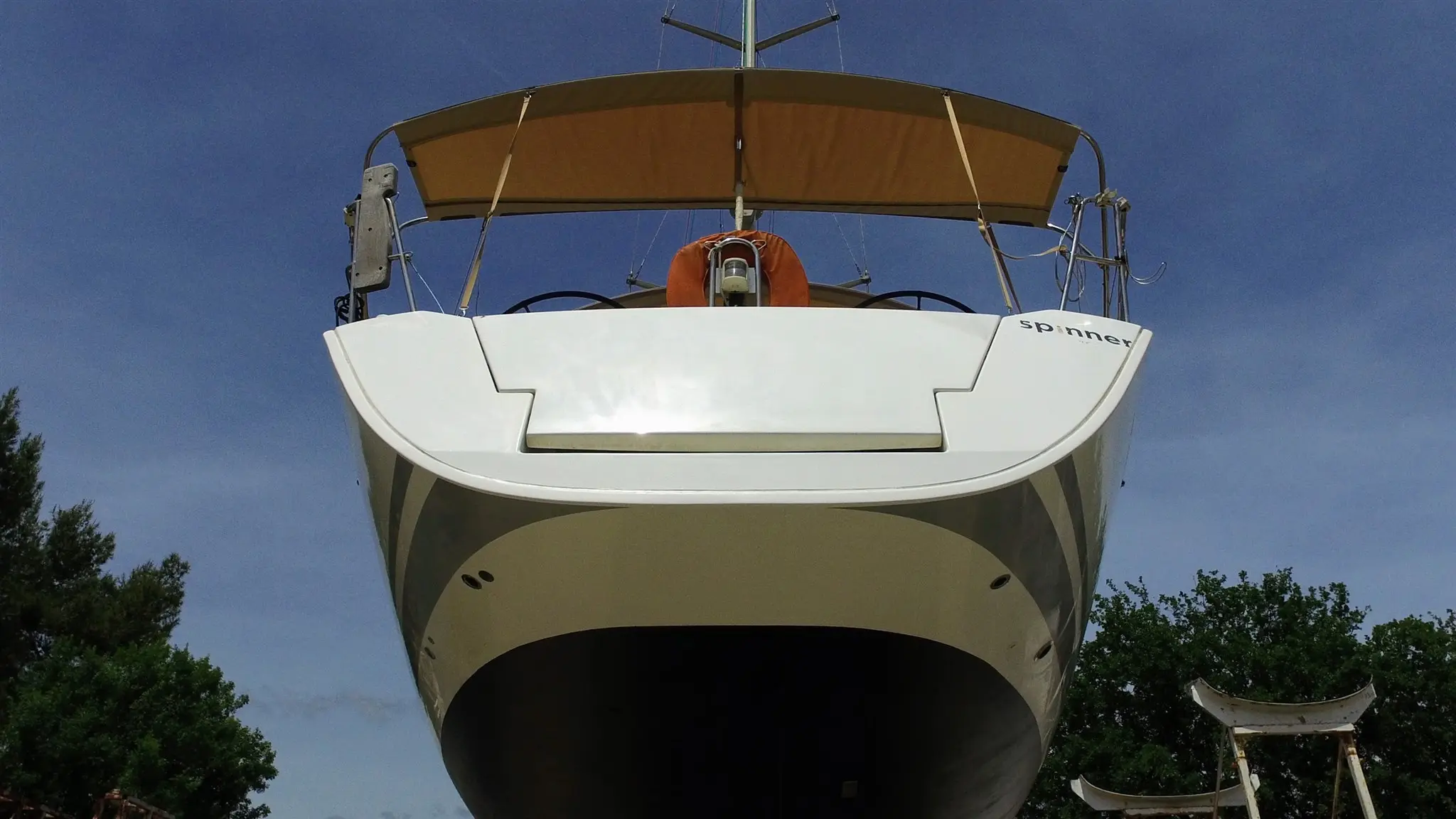 Beneteau First 50 — Vue en contre-plongée de l’arrière d’un bateau blanc équipé d’un taud.