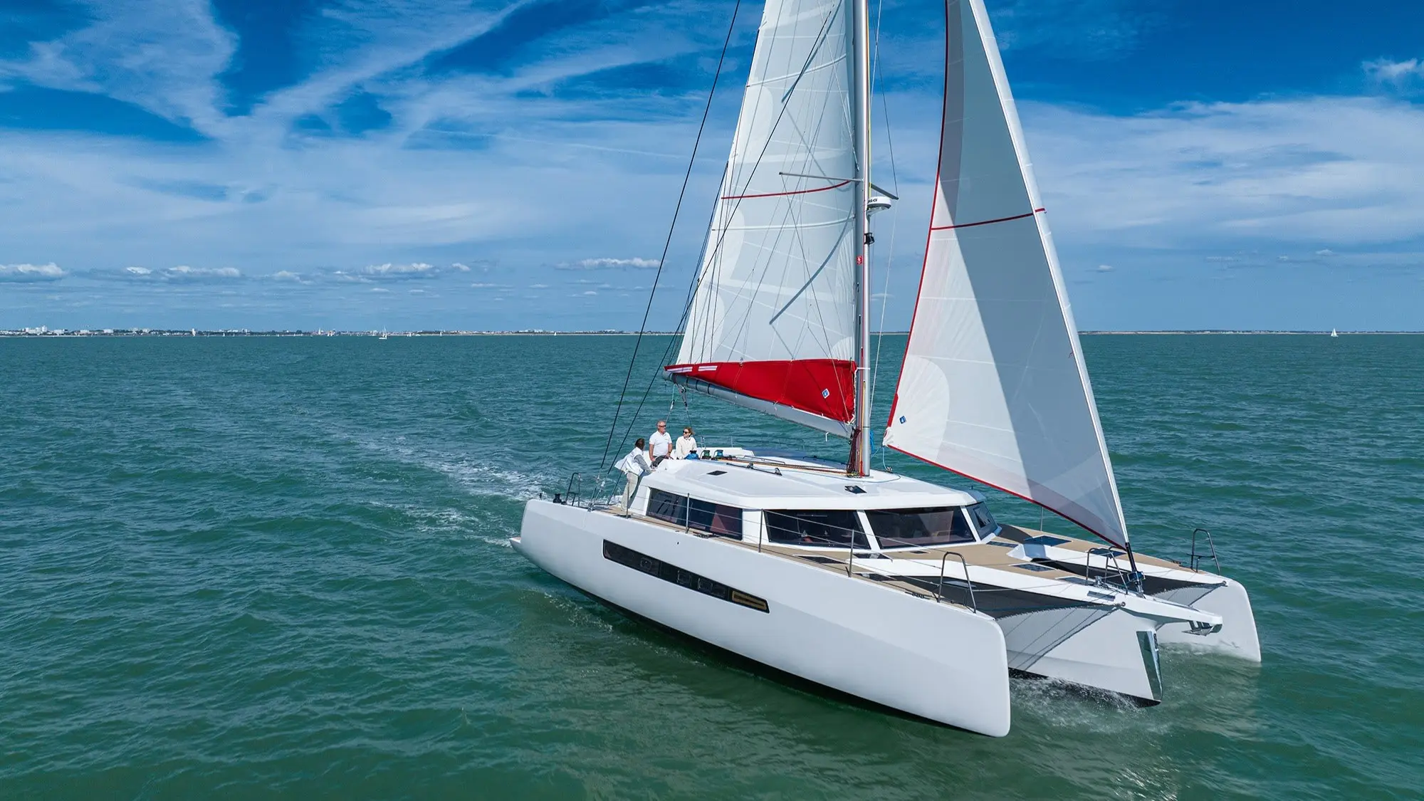 Neel Trimarans Neel 52 — Catamaran à voile blanc naviguant sur une mer calme sous un ciel bleu