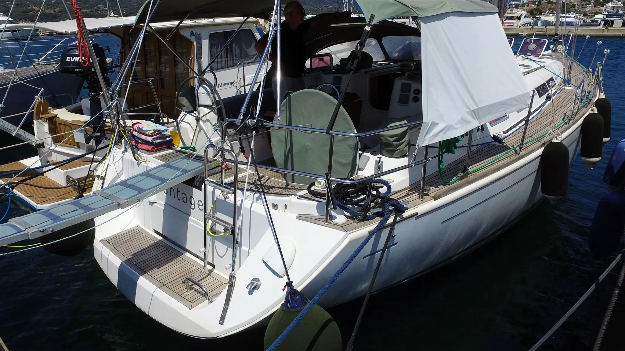 Dufour 455 — Voilier amarré vu de trois quarts arrière, avec cockpit couvert et panneaux solaires.