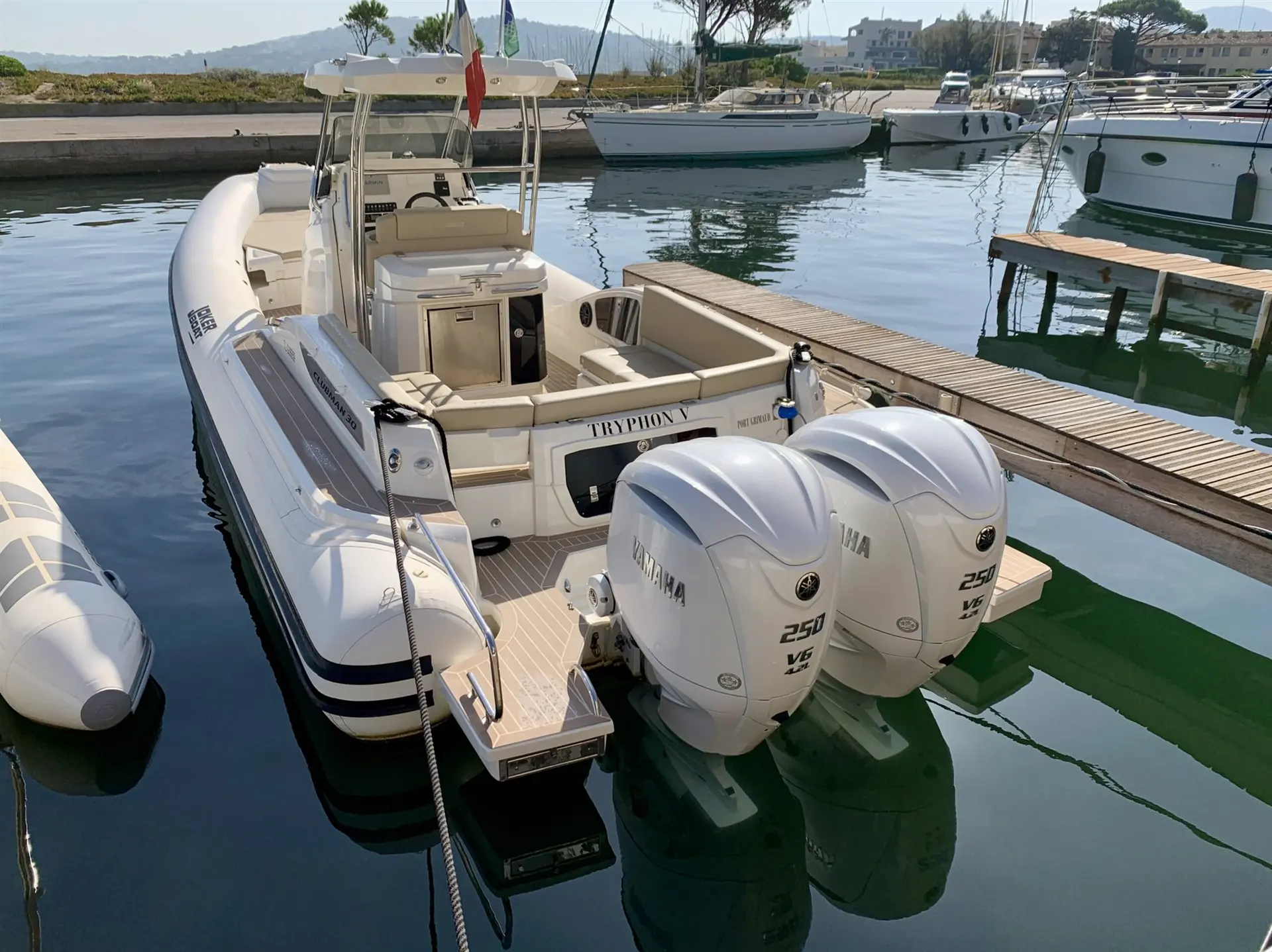 Joker Boat Clubman — Bateau semi-rigide amarré, vu de trois quarts arrière, avec deux moteurs hors-bord.