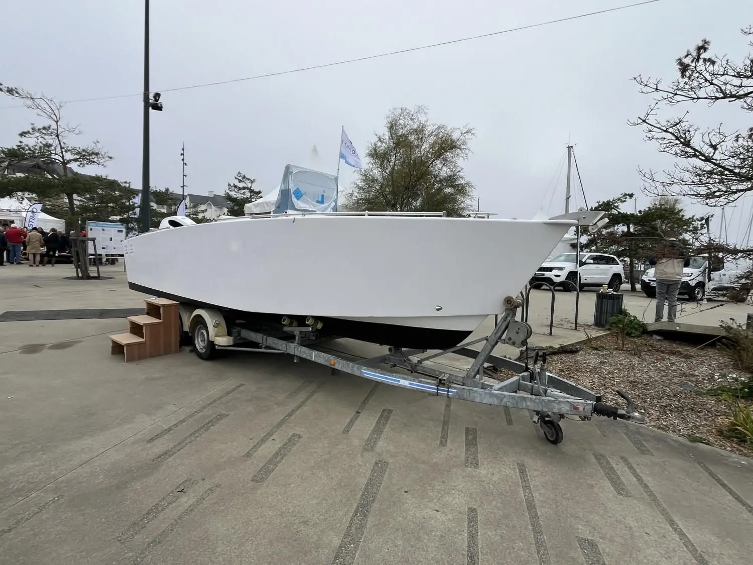Custom AKA 690 — Bateau blanc présenté sur une remorque lors d’un salon nautique.
