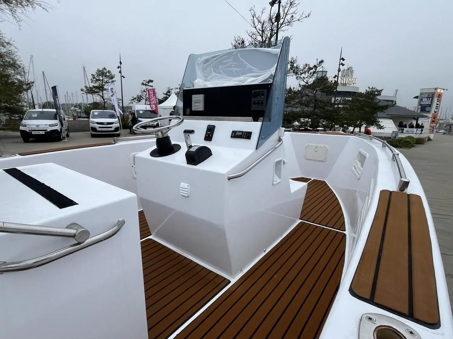 Custom AKA 690 — Vue du pont avant et de la console de pilotage d’un bateau exposé à quai.
