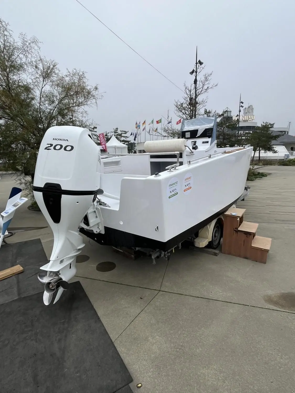 Custom AKA 690 — Bateau blanc exposé sur remorque, équipé d’un moteur hors-bord Honda 200.