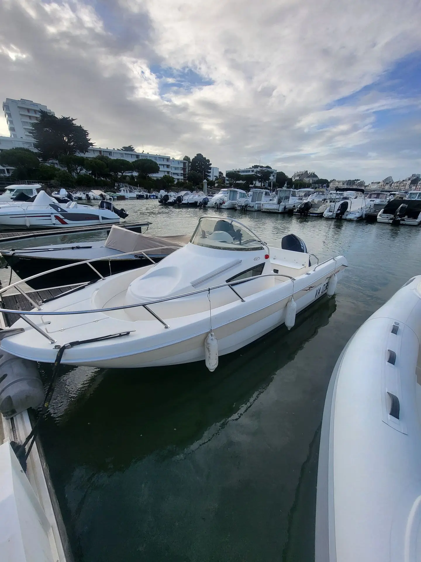 Pro Marine Belone 550 — Bateaux à moteur amarrés dans un port de plaisance sous un ciel nuageux.