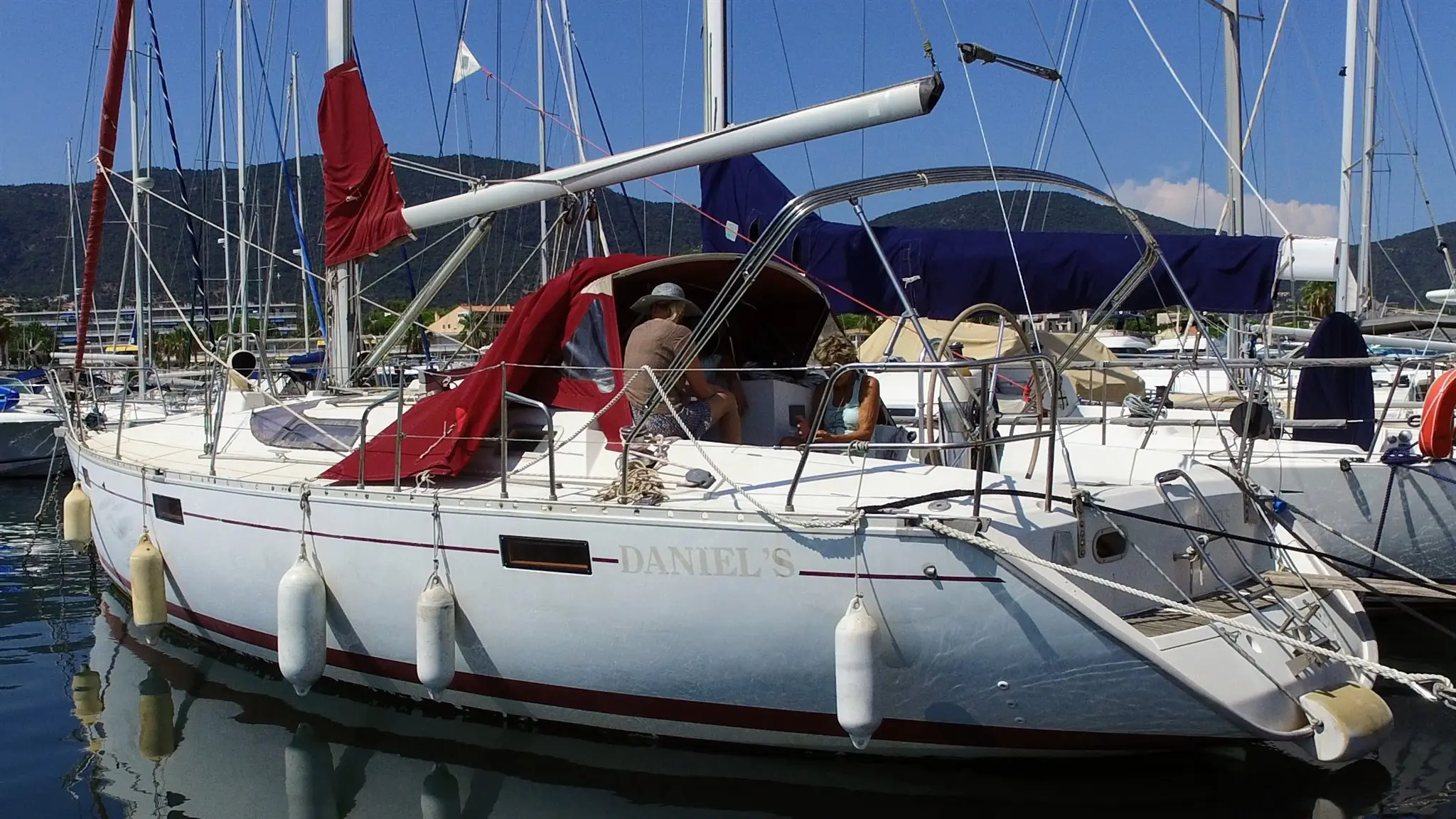 Beneteau Oceanis 390 — Voilier blanc amarré dans un port, vu de trois quarts, avec une personne à bord.