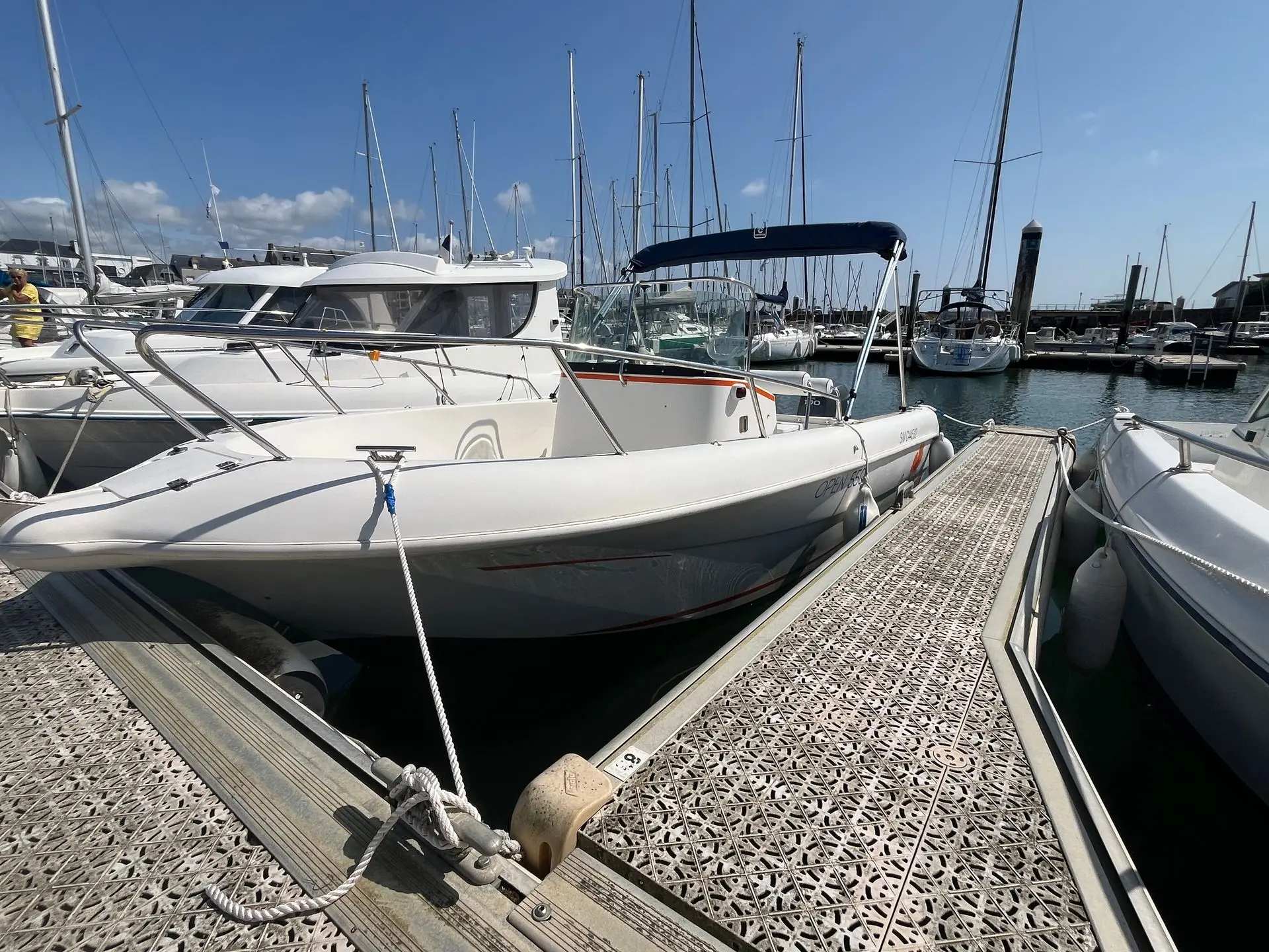 Pacific Craft 550 Open — Bateau à moteur blanc amarré dans un port de plaisance.