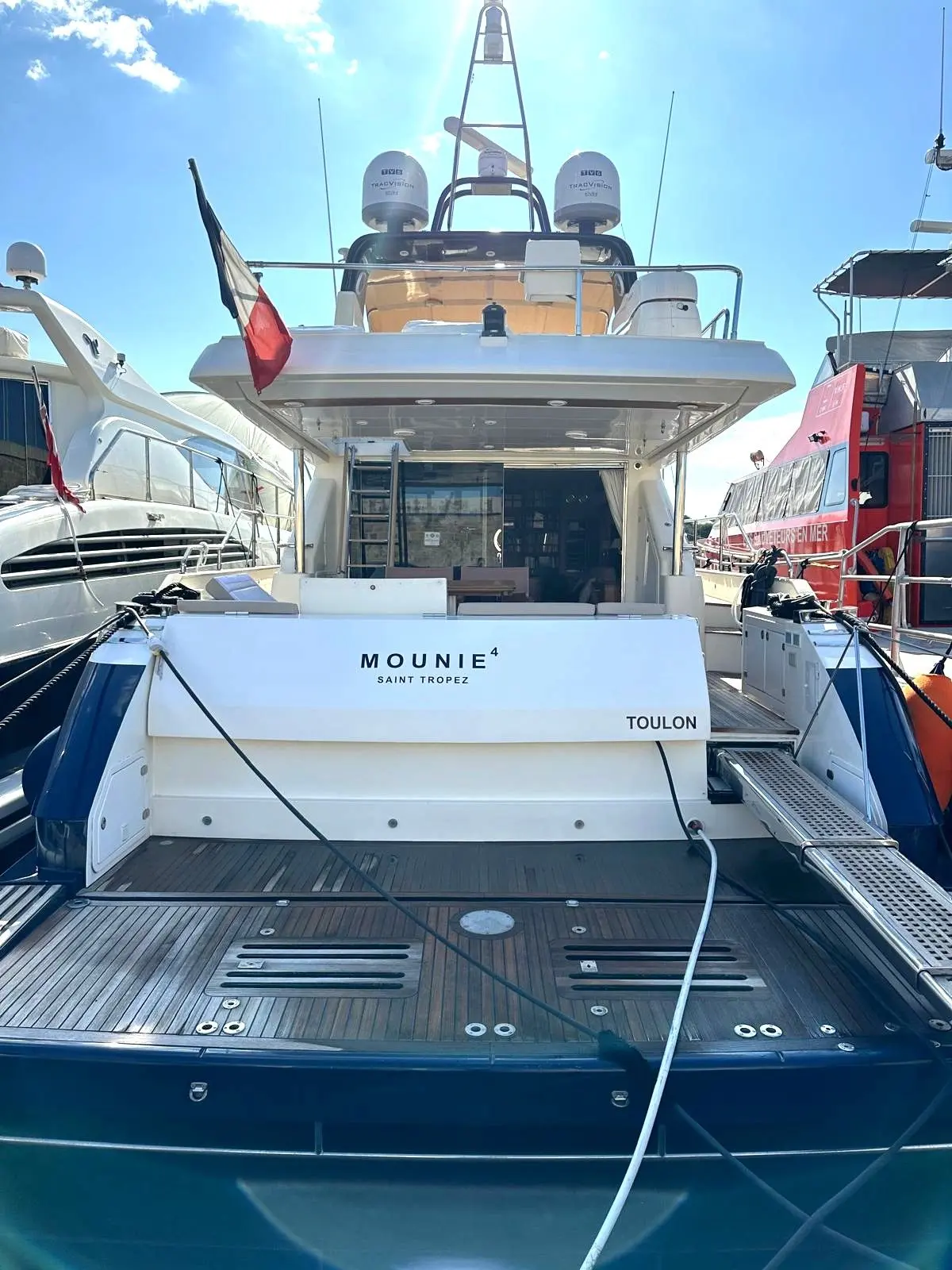 Guy Couach 2200 — Vue arrière d’un yacht amarré, avec plateforme de bain et poste de pilotage supérieur.
