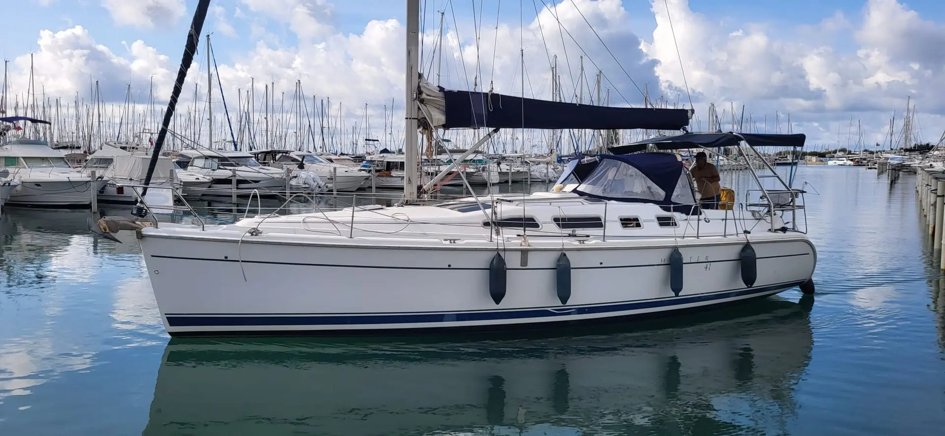 Hunter 41 — Voilier blanc amarré dans une marina, vu de profil tribord.
