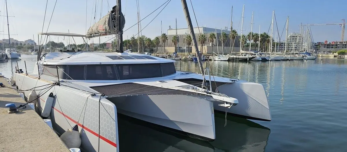 Neel Trimarans 43 Performance — Trimaran amarré dans un port, vu de trois quarts avant par temps dégagé.