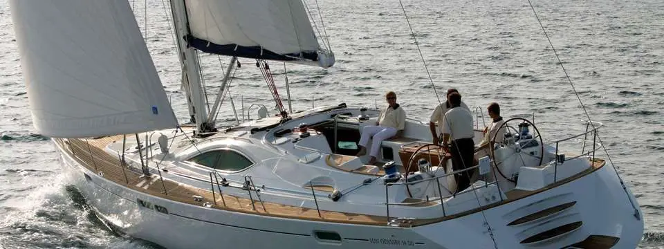 Jeanneau Sun Odyssey 54 DS — Voilier blanc naviguant à la voile, avec plusieurs personnes dans le cockpit.