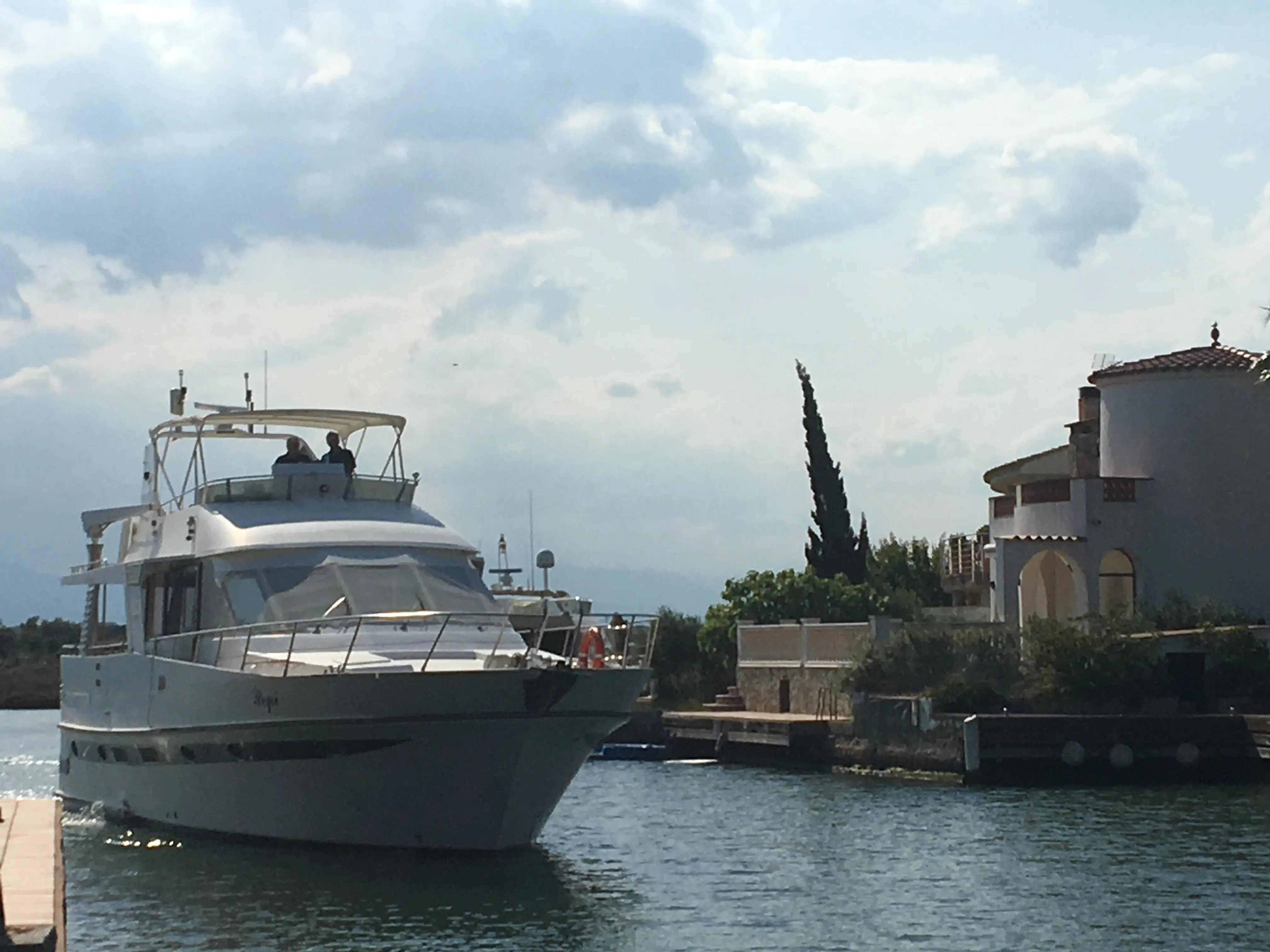 Edership 60 — Bateau à moteur blanc vu de trois quarts dans un port, avec deux personnes à bord.