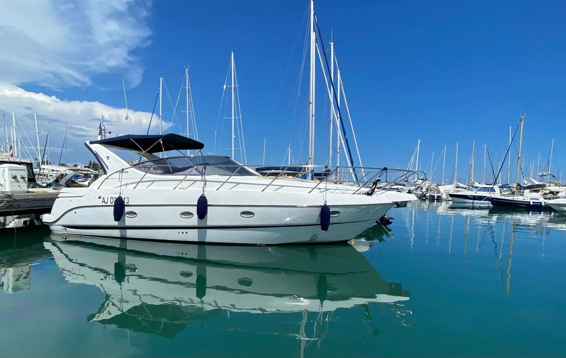 Sessa Marine C35 — Bateau à moteur blanc amarré dans une marina, vu de profil sur l’eau.