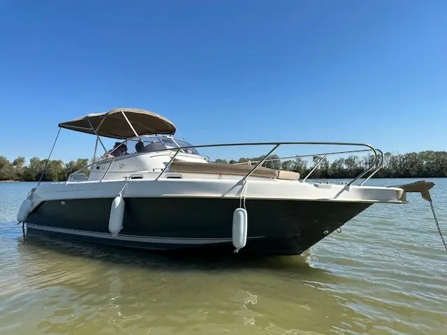 B2 Marine 752 — Bateau à moteur blanc photographié de trois quarts sur l’eau, avec taud de soleil.