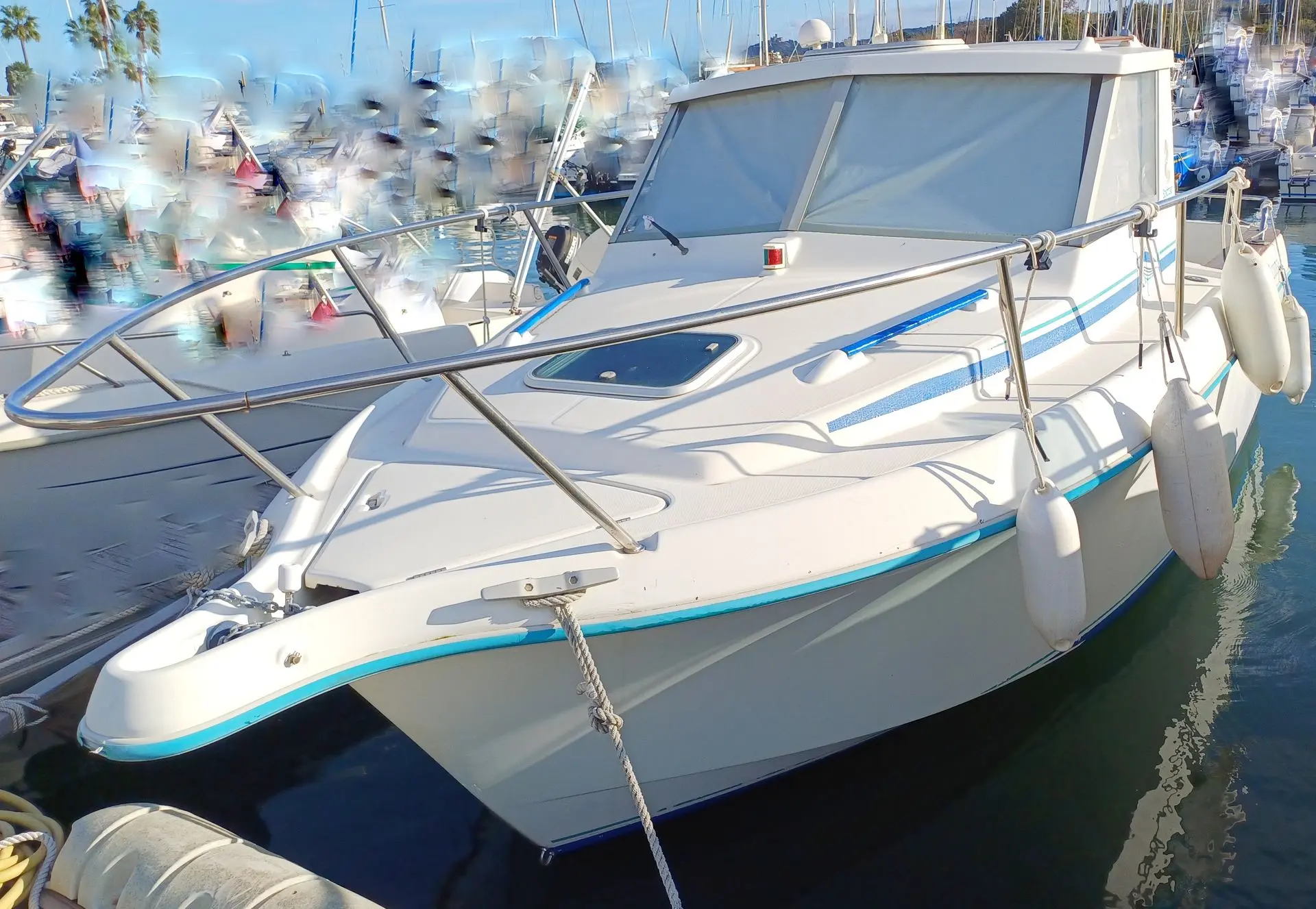 Beneteau Antares 605 — Vedette blanche à cabine amarrée dans un port de plaisance.