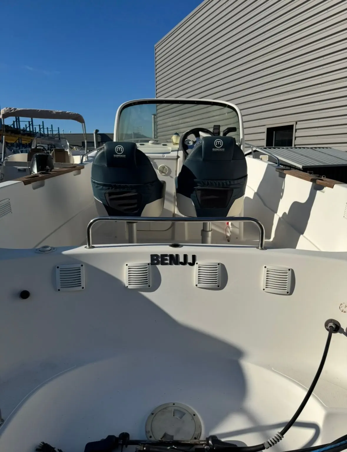 Quicksilver 630 Open Commander — Vue de l’intérieur de la proue avec deux sièges, console et pare-brise.