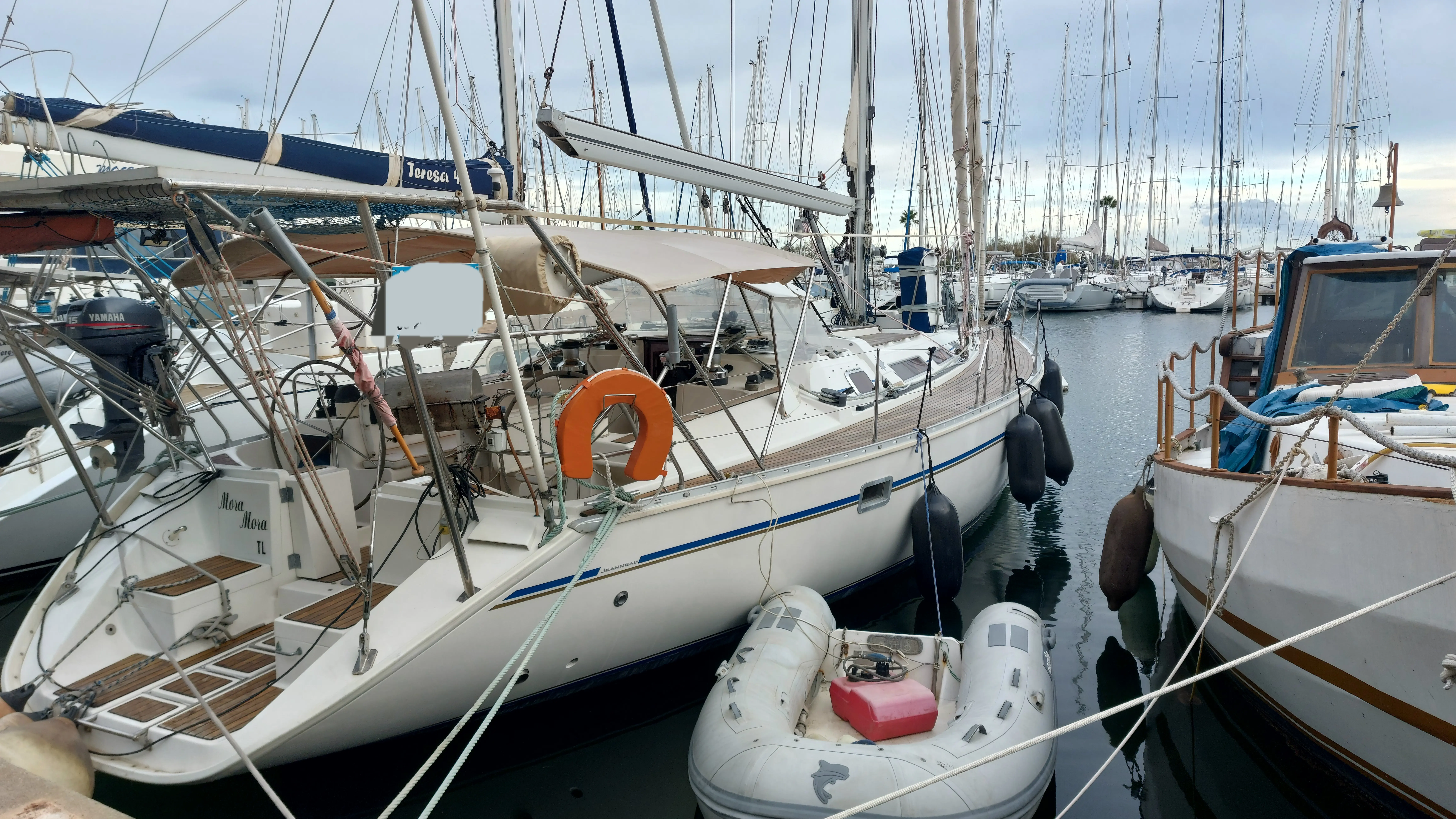 Jeanneau Sun Odyssey 51 — Voilier blanc amarré dans une marina, entouré d'autres bateaux.