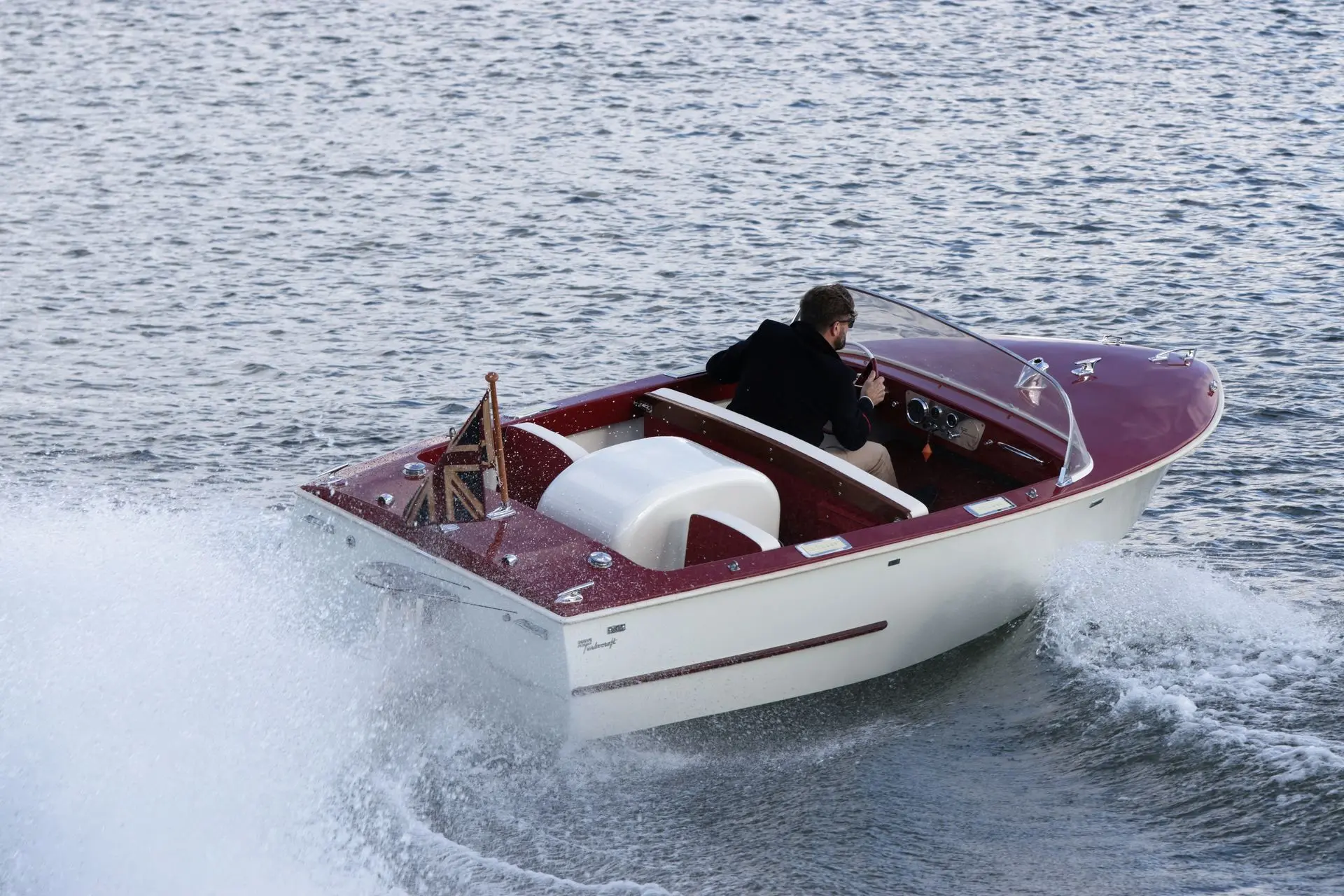 Dowty Turbocraft — Bateau de plaisance bicolore naviguant à vive allure sur l’eau.