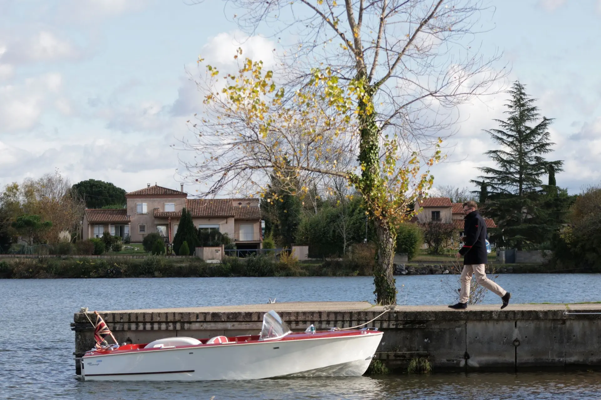 Dowty Turbocraft — Bateau à moteur rouge et blanc naviguant devant une berge arborée.