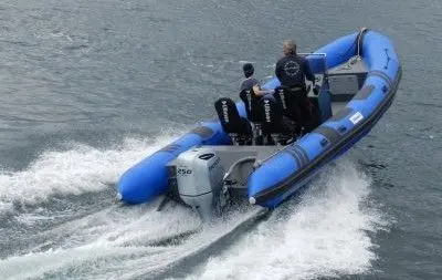 Tarpon DV 75 — Bateau pneumatique gris et bleu naviguant à vive allure avec plusieurs personnes à bord.