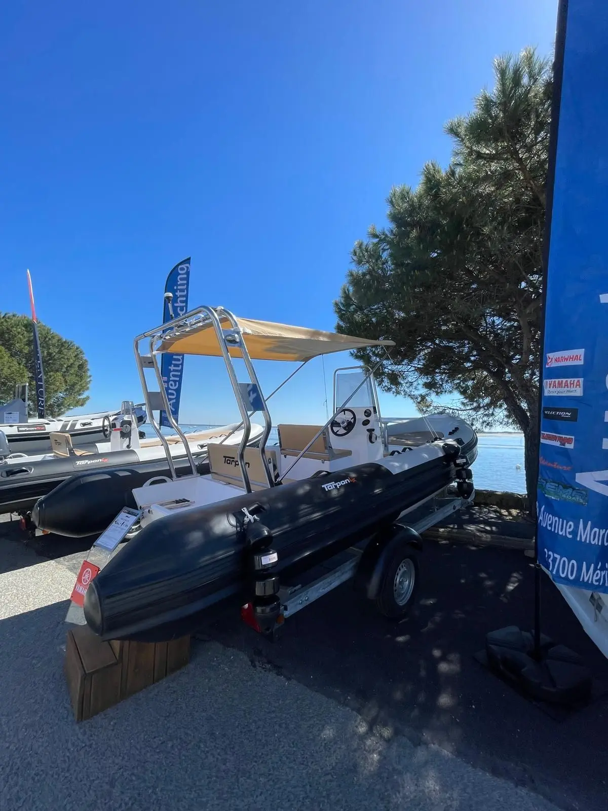 Tarpon 590 Lx — Bateau semi-rigide exposé sur remorque, avec console de pilotage et taud.