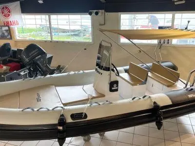 Tarpon 590 Lx — Semi-rigide exposé en intérieur, vu de trois quarts côté bâbord.