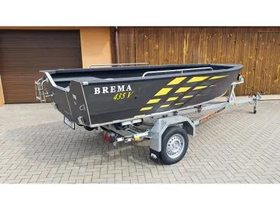Brema 435V Fishing — Bateau gris et jaune présenté sur sa remorque devant un garage.
