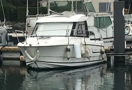 Jeanneau Merry Fisher 645 — Bateau à moteur blanc amarré dans un port, vu de trois quarts avant.