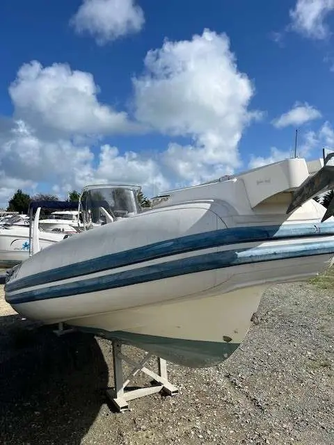 Capelli Tempest 770 — Bateau semi-rigide blanc et bleu présenté à terre sur un support.
