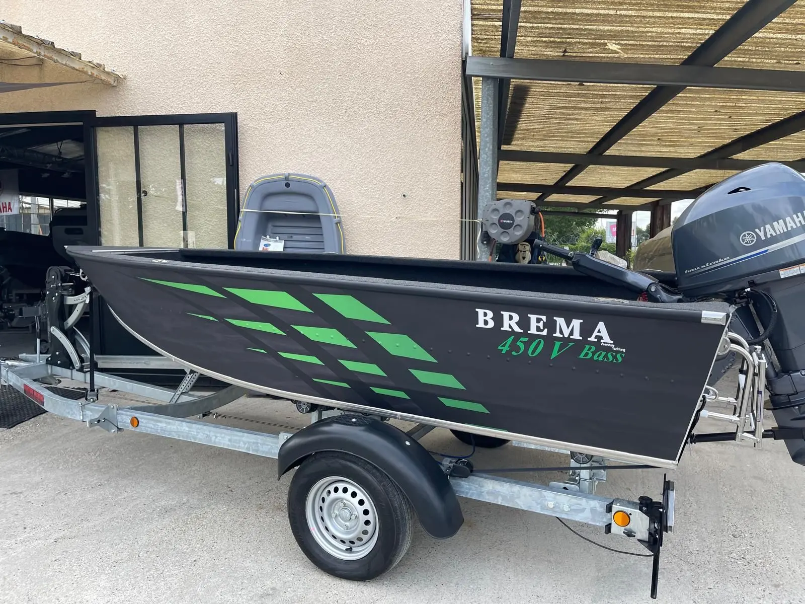 Brema 450V Pro Bass — Bateau de pêche noir et vert présenté sur une remorque, vu de profil.