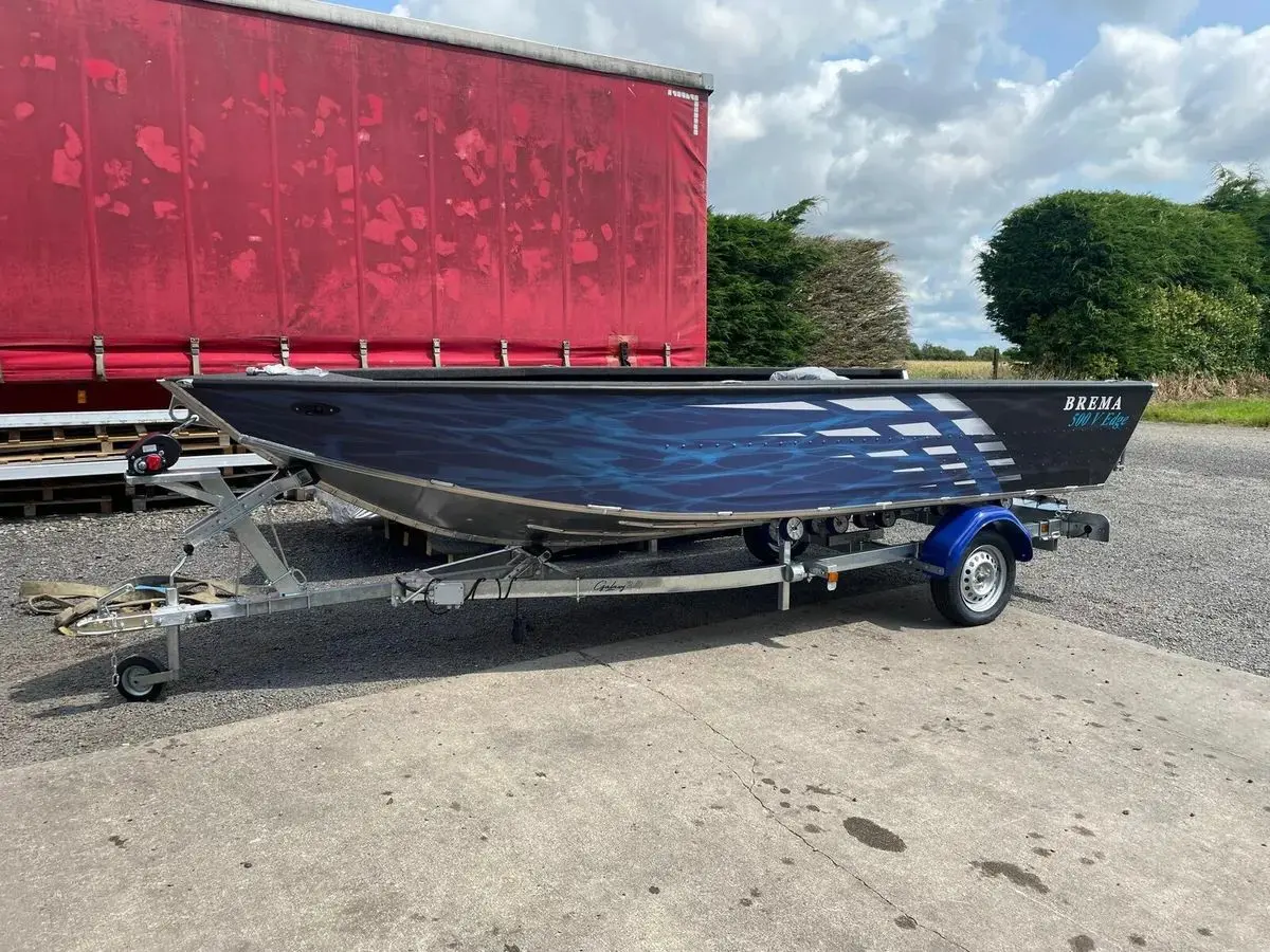 Brema 500V Edge — Bateau à moteur bleu et noir présenté sur une remorque, vu de profil.
