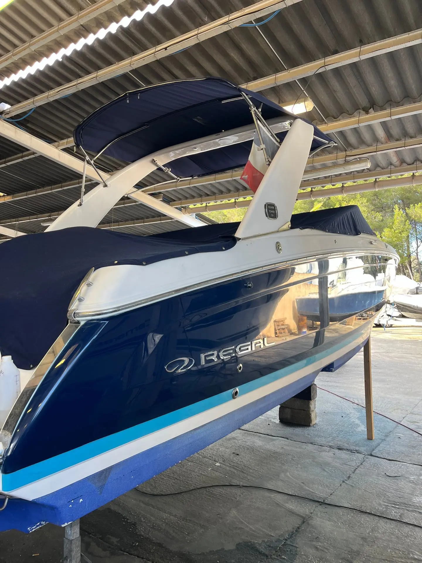Regal 26 Fasdeck — Vue rapprochée de la poupe d’un bateau bleu et blanc sous abri.